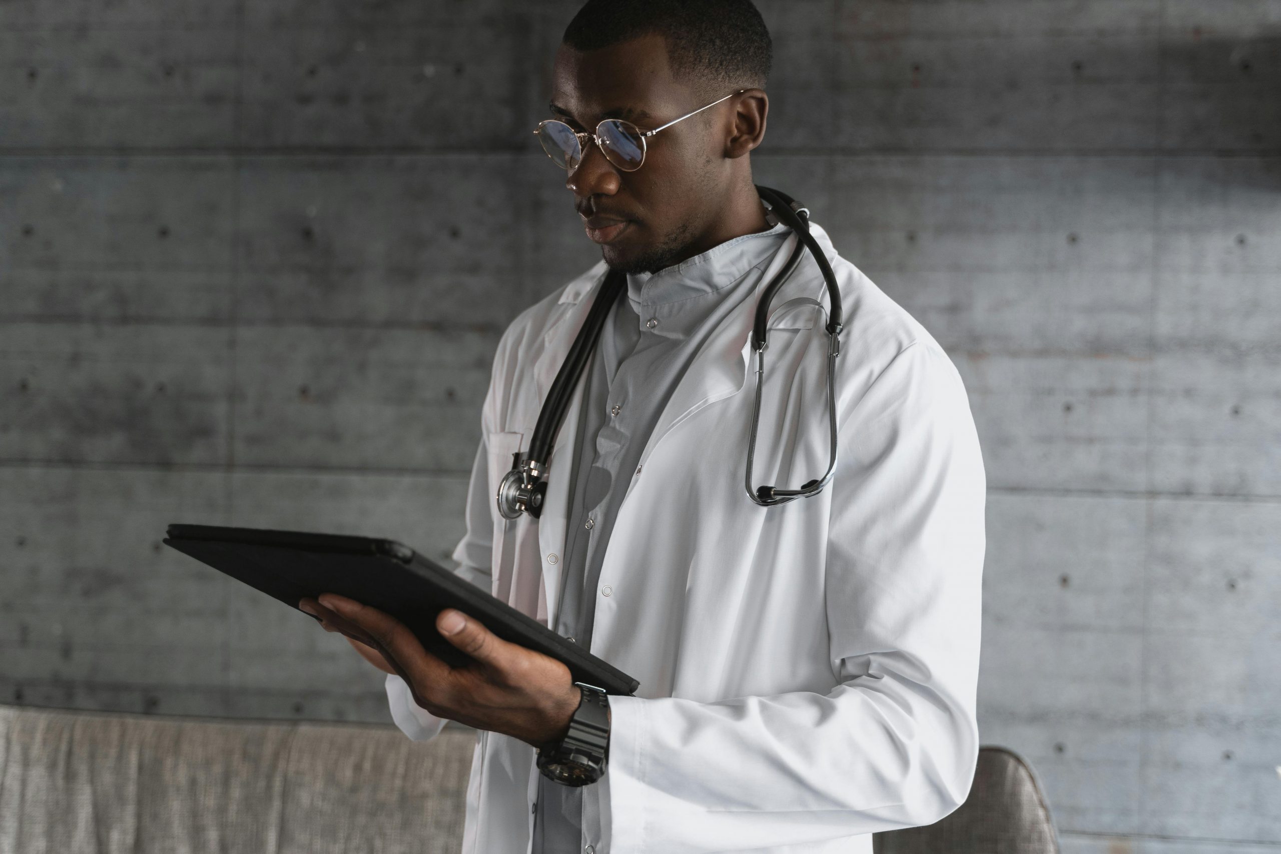 healthcare worker using Life Backup Plan on tablet African American Male Physician using Life Backup Plan Digital Health and Safety mobile app to improve patient experience and health outcomes on a tablet